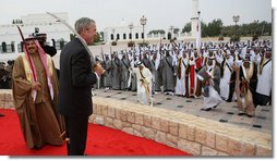 President George W. Bush enjoys the moment with performers Saturday, Jan. 12, 2008, after being presented with a sword by King Hamad Bin Isa Al-Khalifa, left, during arrival ceremonies in Manama, Bahrain. White House photo by Eric Draper