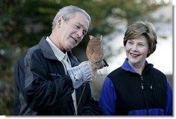 President George W. Bush and Mrs. Laura Bush have a close look at a screech owl Saturday, Oct. 20, 2007 at the Patuxent Research Refuge in Laurel, Md., where President Bush discussed steps his Administration is creating for a series of cooperative conservation steps to preserve and restore critical stopover habitat for migratory birds in the United States. White House photo by Eric Draper