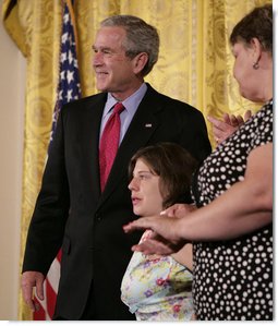 President George W. Bush embraces stem cell patient Kaitlyne McNamara following his address on the reasons he vetoed S.5, the “Stem Cell Research Enhancement Act of 2007,” in the East Room of the White House Wednesday, June 20, 2007. McNamara was born with spina bifida, a disease that damaged her bladder, her doctors isolated healthy stem cells in a piece of her own bladder and used them to grow her a new bladder.  White House photo by Eric Draper