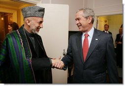 President George W. Bush welcomes Afghanistan President Hamid Karzai to a meeting at the Waldorf Astoria Hotel Wednesday morning, Sept. 26, 2007 in New York. The two leaders met following their participation in meetings at the United Nations. White House photo by Eric Draper