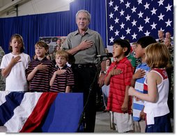 President George W. Bush joins a group of children during the Pledge of Allegiance Wednesday, July 4, 2007, at a Fourth of July visit with members of the West Virginia Air National Guard 167th Airlift Wing and their family members in Martinsburg, W. Va. White House photo by Chris Greenberg