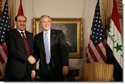 President George W. Bush and Prime Minister Nouri Al-Maliki of Iraq, shake hands after their meeting Tuesday, Sept. 25, 2007, at the Waldorf-Astoria Hotel in New York City. The President told his Iraq counterpart, ".We're with you, Prime Minister. We thank you for the courage of the Iraqi people." White House photo by Eric Draper