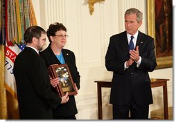 President George W. Bush leads the applause in honor of Private First Class Ross A. McGinnis, U.S. Army, after presenting the Congressional Medal of Honor posthumously to his parents, Tom and Romayne McGinnis, of Knox, Pennsylvania, during ceremonies Monday, June 6, 2008, at the White House. White House photo by Chris Greenberg