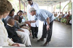 President George W. Bush greets a young child on his arrival Monday, Feb. 18, 2008, for a tour of the outpatient clinic of the Meru District Hospital in Arusha, Tanzania. White House photo by Eric Draper